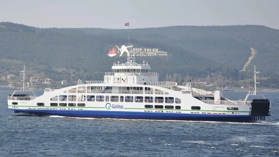 Alınteri 18 feribotu Çanakkale Boğazı'nda, arka planda Nusret Mayın Gemisi Müzesi