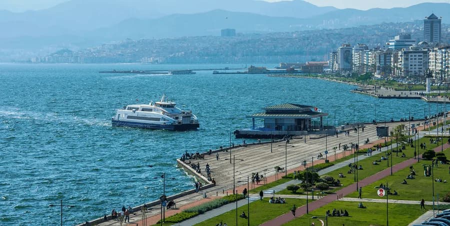 Kordon boyundaki İZDENİZ iskelesi ve yanaşan vapur, sahil şeridi ve yeşil alan