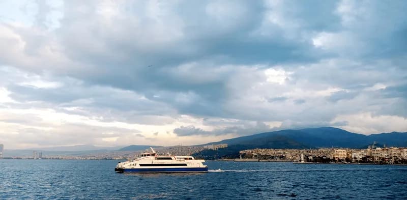Körfez ağzında bulutlu havada seyreden İZDENİZ yolcu vapuru